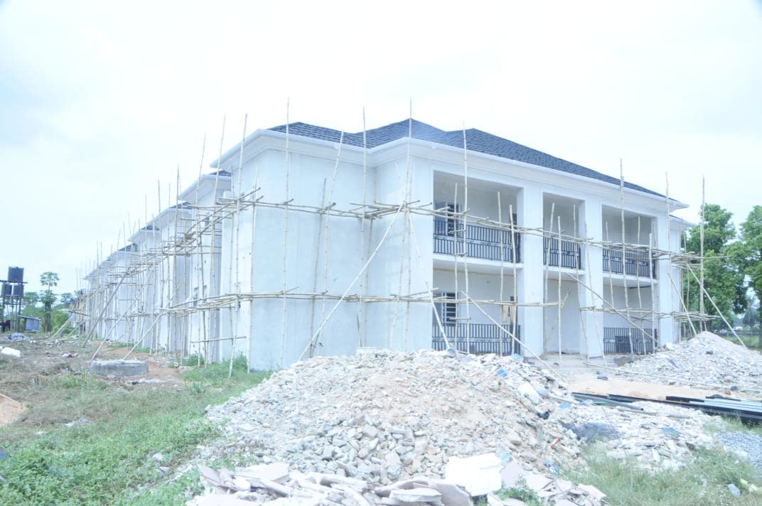 Long elevation under finishing. The full length of the two-storey block seen from the lawn.