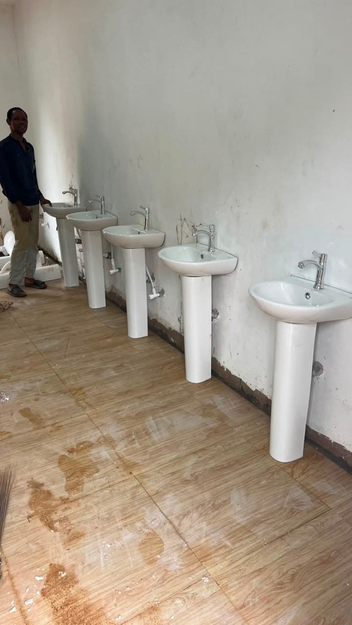 Washroom fit-out. Row of wash basins in a tiled washroom.